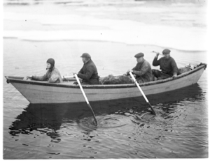 Image of Three White men, 1 Inuit in dory